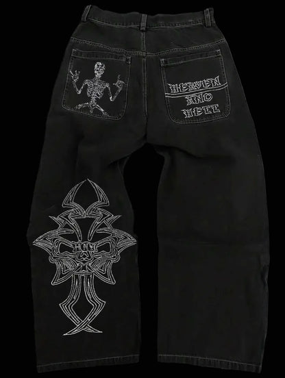Black jeans with white embroidered designs on a white background